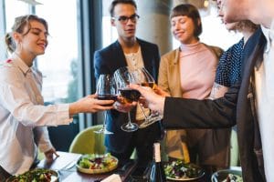 Pessoas em almoço brindando com vinho