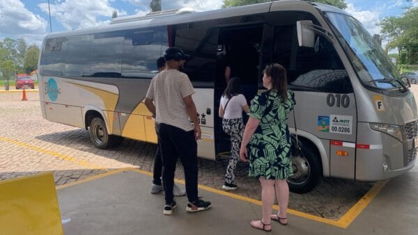 pessoas entrando em micro ônibus de viagem