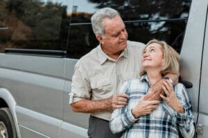 casal mais velho abraçados em frente a van