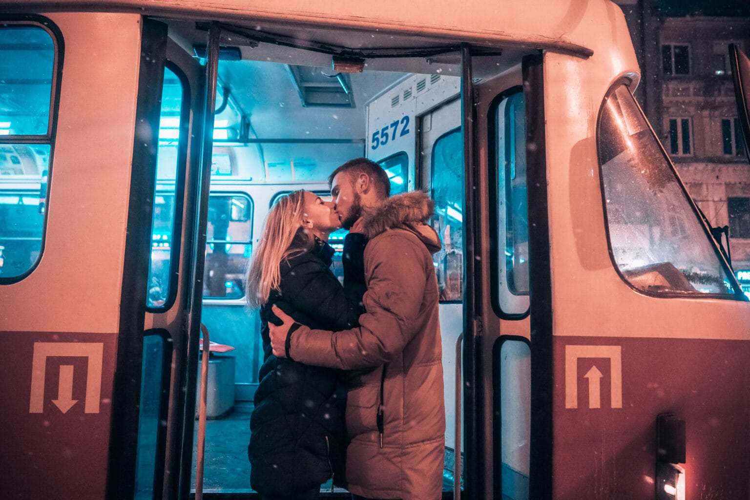 Casal se beijando na frente de porta de ônibus