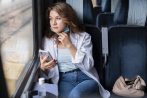 Mulher sentada em poltrona de ônibus olhando pela janela